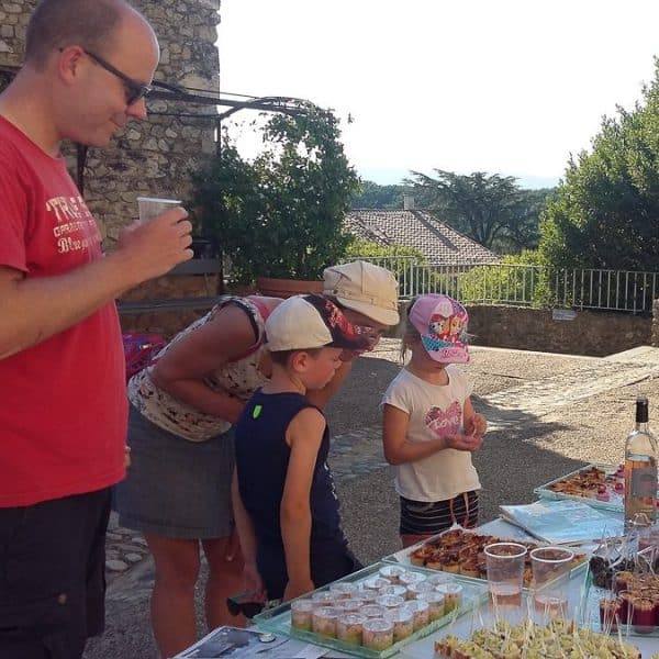 Famille qui dégustent des produits du terroir de la Vallée de la Drôme devant l'office de tourisme de Mirmande