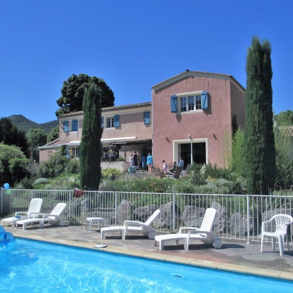 Piscine en premier plan et Maison d'hôte rose